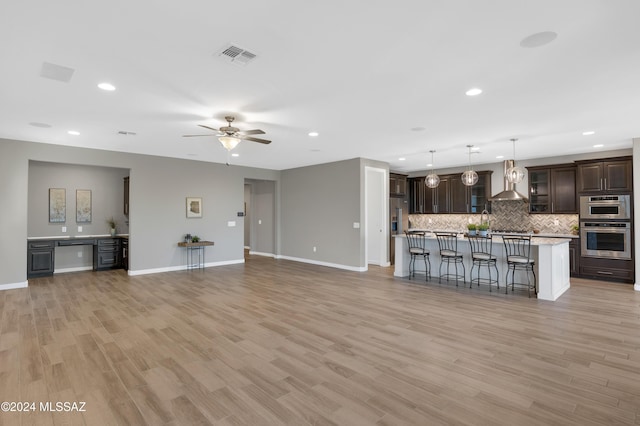 unfurnished living room featuring ceiling fan and light hardwood / wood-style floors