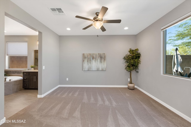 carpeted spare room with ceiling fan