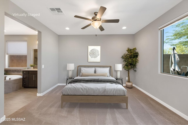 bedroom with ceiling fan, connected bathroom, and light carpet