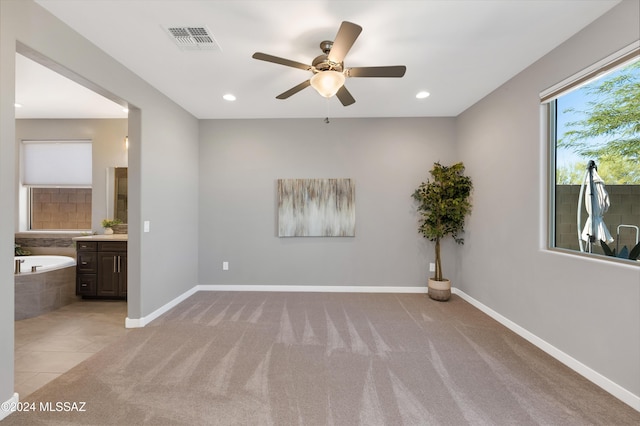 spare room featuring ceiling fan and light carpet