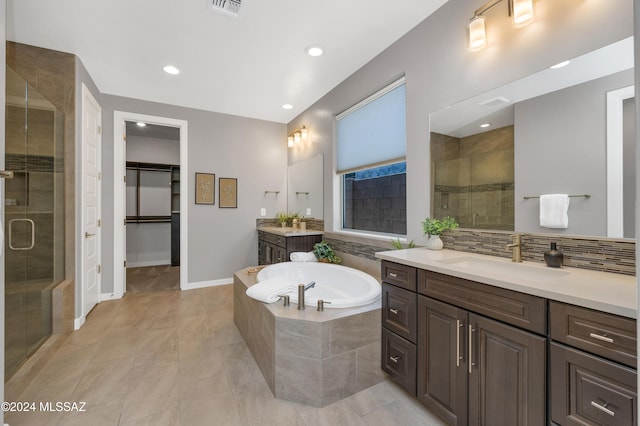 bathroom with vanity, backsplash, and shower with separate bathtub