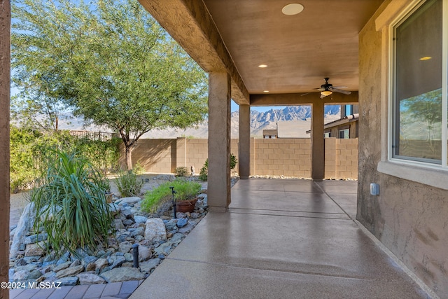 view of patio / terrace featuring ceiling fan and a mountain view