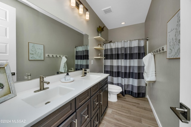 bathroom with toilet, vanity, and hardwood / wood-style flooring