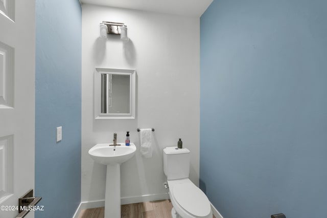 bathroom with hardwood / wood-style floors and toilet