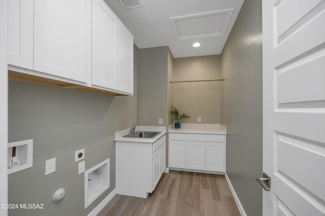 clothes washing area featuring sink, cabinets, light hardwood / wood-style flooring, washer hookup, and hookup for an electric dryer