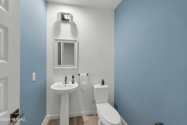 bathroom featuring hardwood / wood-style flooring and toilet