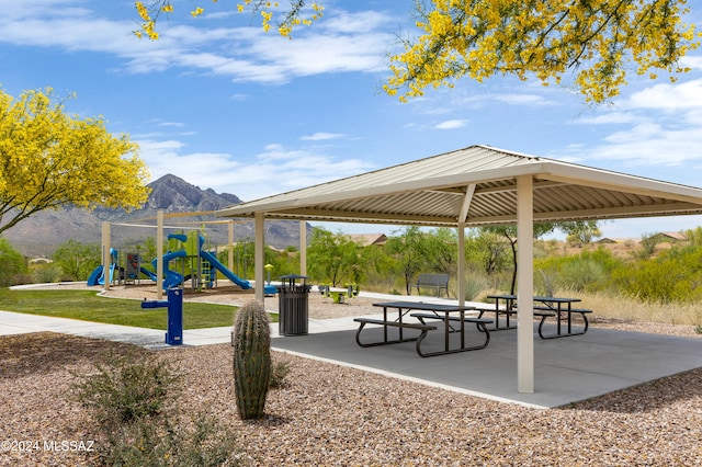 surrounding community with a playground, a mountain view, and a gazebo