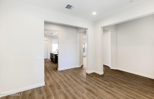 spare room with hardwood / wood-style floors and sink