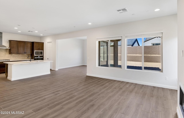 unfurnished living room with sink and light hardwood / wood-style flooring