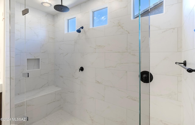 bathroom featuring a shower with door and a wealth of natural light