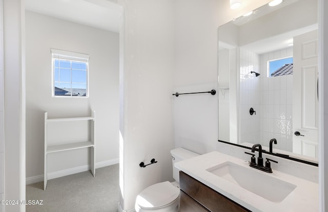 bathroom featuring toilet, a tile shower, and vanity