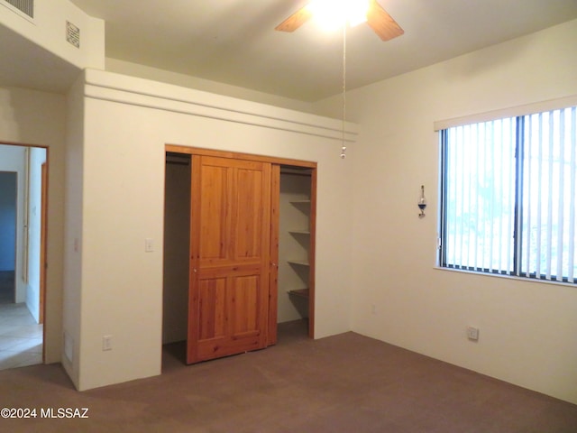 unfurnished bedroom with carpet flooring, a closet, and ceiling fan