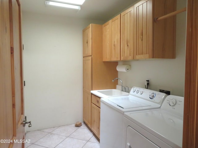 washroom featuring sink, light tile patterned floors, cabinets, and independent washer and dryer