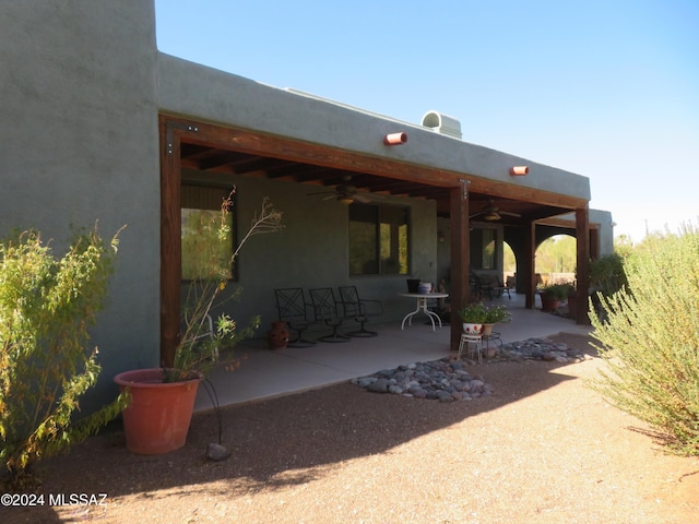 rear view of house featuring ceiling fan and a patio