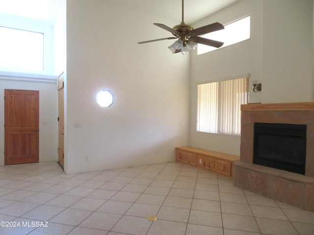 unfurnished living room featuring a high ceiling, light tile patterned flooring, and ceiling fan