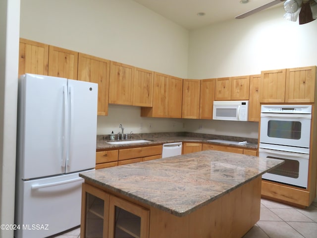 kitchen featuring white appliances, a high ceiling, a kitchen island, light tile patterned flooring, and sink