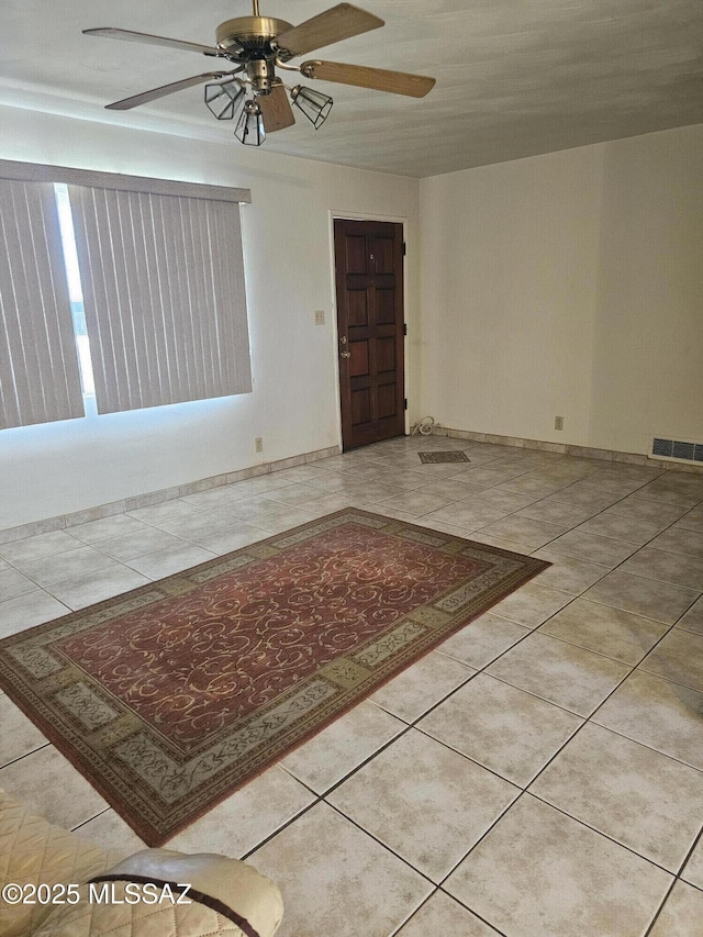 tiled empty room with ceiling fan