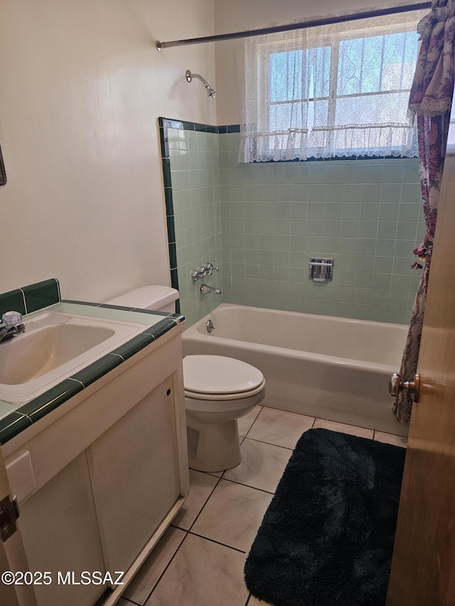 full bathroom featuring tile patterned flooring, tiled shower / bath combo, toilet, and vanity