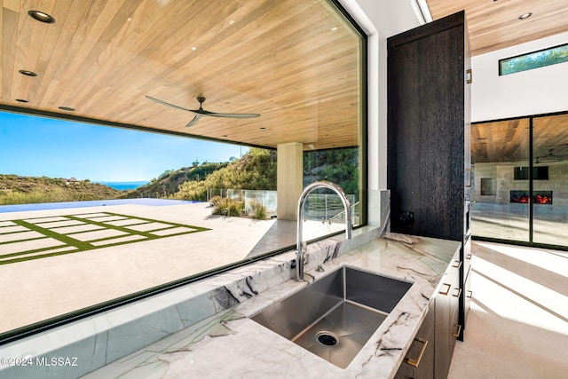 view of patio / terrace featuring a mountain view, sink, and ceiling fan