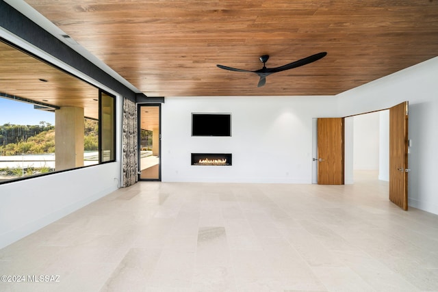 3569 E Secret Canyon Pl, Tucson, AZ 85718 - unfurnished living room with wooden ceiling, ceiling fan, a warm lit fireplace, and baseboards
