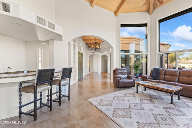 living room with vaulted ceiling with beams, a notable chandelier, and wood ceiling