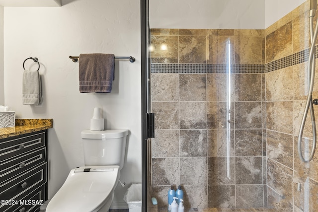 bathroom featuring vanity, an enclosed shower, and toilet