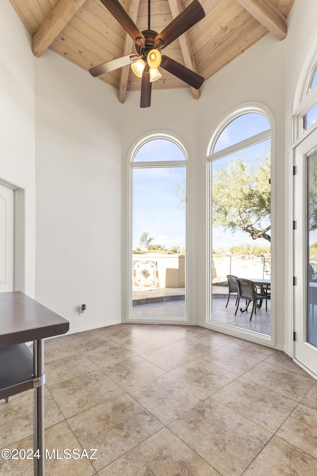 unfurnished dining area featuring beam ceiling, ceiling fan, and wooden ceiling