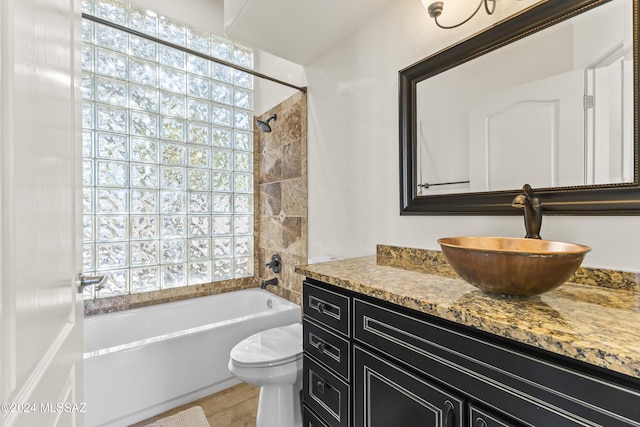 full bathroom featuring vanity, toilet, a wealth of natural light, and tiled shower / bath combo