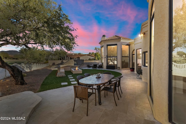 patio terrace at dusk featuring a fire pit