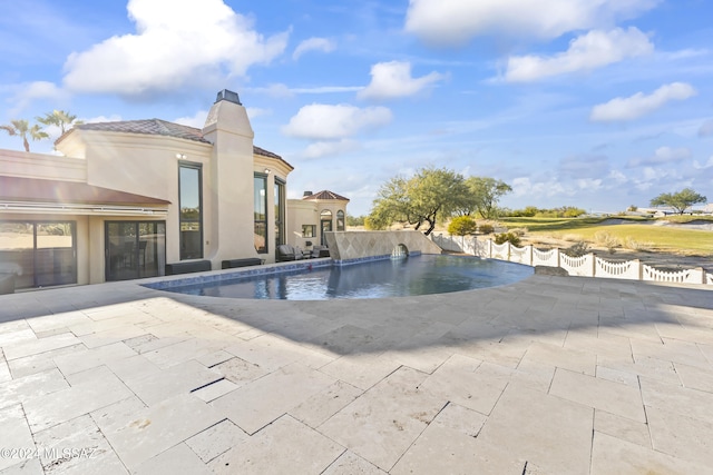 view of swimming pool with pool water feature and a patio