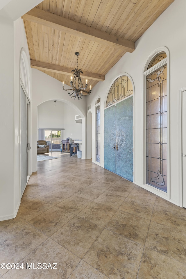 entrance foyer featuring a chandelier, lofted ceiling with beams, and wood ceiling