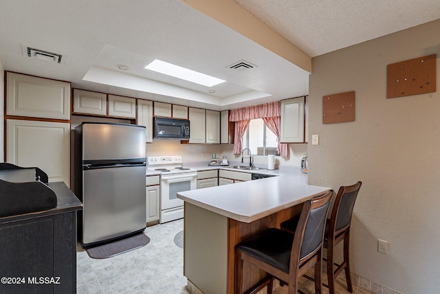 kitchen with sink, stainless steel fridge, a kitchen breakfast bar, white electric range oven, and a tray ceiling