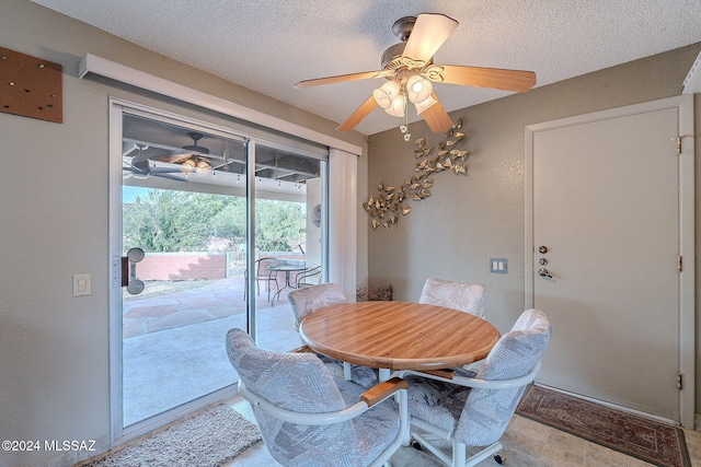 dining space featuring ceiling fan and a textured ceiling