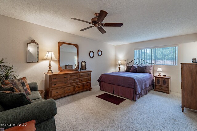 carpeted bedroom featuring a textured ceiling and ceiling fan