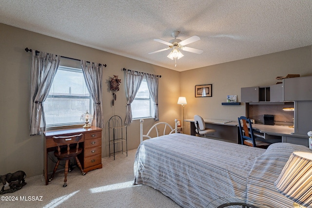 carpeted bedroom featuring ceiling fan and a textured ceiling