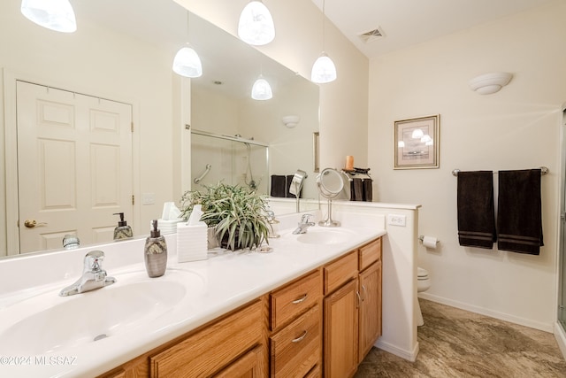 bathroom featuring toilet, vanity, and a shower with door