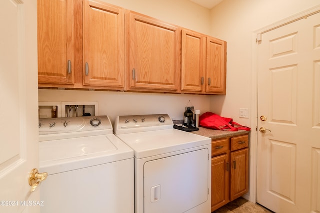 laundry area with cabinets and washing machine and clothes dryer