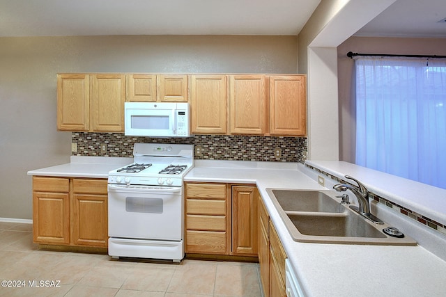 kitchen featuring tasteful backsplash, sink, white appliances, and light tile patterned floors