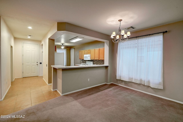 kitchen with ceiling fan with notable chandelier, kitchen peninsula, light carpet, and white appliances