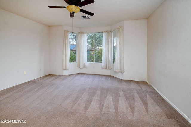 unfurnished room with ceiling fan and light colored carpet