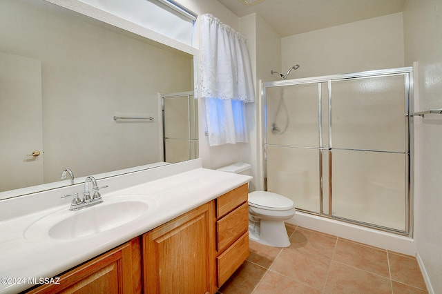 bathroom with tile patterned flooring, vanity, toilet, and an enclosed shower