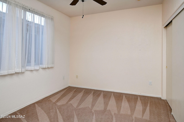 unfurnished room featuring ceiling fan and carpet floors