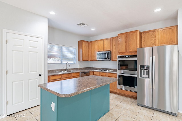 kitchen featuring light tile patterned floors, stainless steel appliances, a sink, visible vents, and a center island