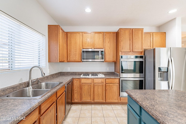 kitchen with light tile patterned floors, dark countertops, appliances with stainless steel finishes, a sink, and recessed lighting