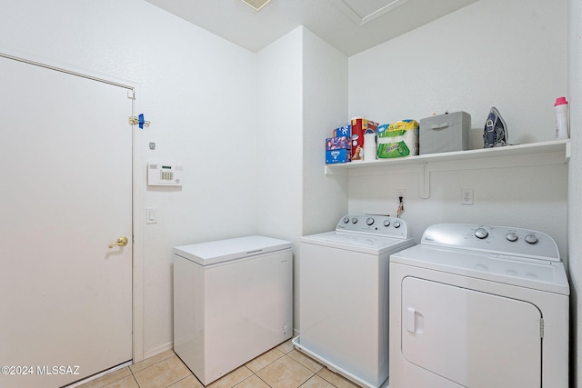 washroom with light tile patterned floors, laundry area, and washing machine and clothes dryer