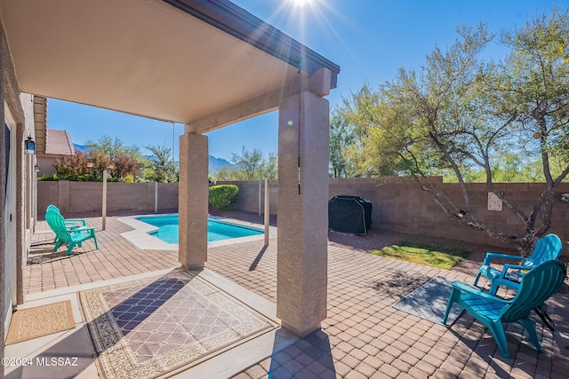 view of patio with a fenced in pool, a fenced backyard, and a grill