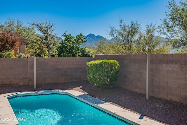 view of swimming pool with a fenced in pool, a fenced backyard, and a mountain view