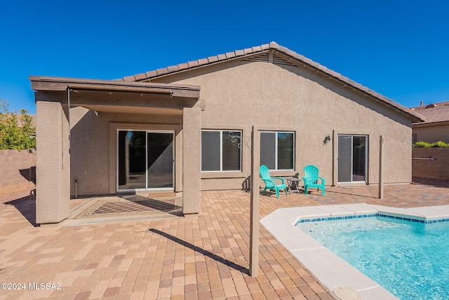 back of property featuring a tiled roof, fence, a patio, and stucco siding