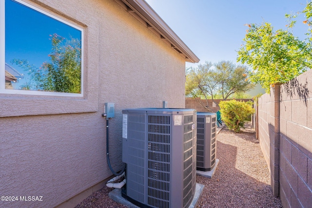 details featuring central AC, a fenced backyard, and stucco siding