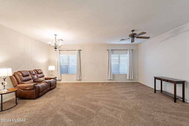 living room with carpet, plenty of natural light, and ceiling fan with notable chandelier